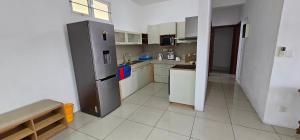 a kitchen with a stainless steel refrigerator and white cabinets at Ollier Plaza Apartments in Port Louis