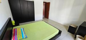 ein Schlafzimmer mit einem grünen Bett mit einer bunten Decke in der Unterkunft Ollier Plaza Apartments in Port Louis
