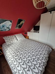 ein Schlafzimmer mit einem Bett und einer roten Wand in der Unterkunft Chez Gilles et Isabelle in Cairon