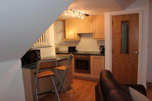 a kitchen with a counter and two chairs in it at Bryher in Wadebridge