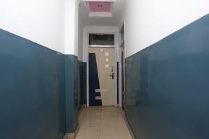 un corridoio con pareti blu e una porta di OYO Hotel Dev a Palwal