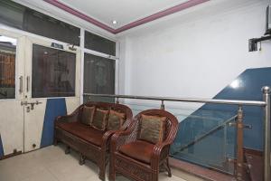2 sedie in vimini sedute sopra un balcone di OYO Hotel Dev a Palwal