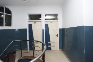 una camera con pareti bianche e blu e una scala di OYO Hotel Dev a Palwal