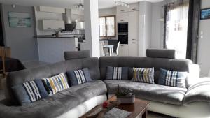 uma sala de estar com um sofá com almofadas em Maison avec Piscine couverte BADEN GOLFE DU MORBIHAN em Baden