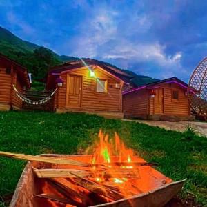 a fire pit in a yard next to a cabin at Dedushi guesthouse &wod cabin-camping place in Gusinje