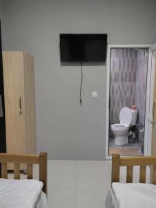 a bedroom with a toilet and a tv on the wall at Ortachala Summer House in Tbilisi City