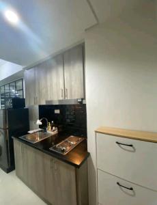 - une cuisine avec un évier et un comptoir dans l'établissement S residences Pasay , near Mall of Asia, à Manille
