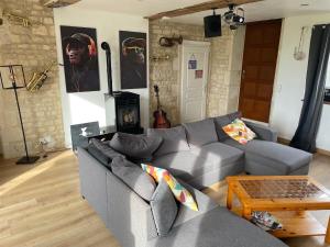 ein Wohnzimmer mit einem Sofa und einem Tisch in der Unterkunft Gîte « Stand by me » avec Spa privatif in Audrieu
