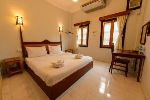 Schlafzimmer mit einem großen Bett, einem Schreibtisch und einem Tisch in der Unterkunft Sabaidee Guesthouse in Luang Prabang + 26 Fotos