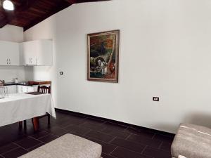 een keuken met een tafel en een schilderij aan de muur bij OA's beach apartment in Vlorë