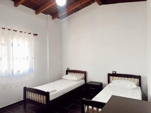 twee bedden in een kamer met een tafel en een raam bij OA's beach apartment in Vlorë