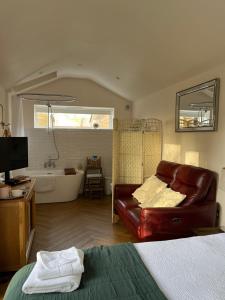 a bedroom with a couch and a tub in a room at The chalet in Chandlers Ford