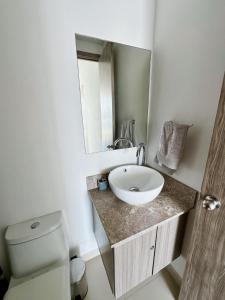 a bathroom with a sink and a toilet and a mirror at Nuevo, amoblado y las mejores vistas de amaneceres in Santa Marta