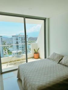 a bedroom with a bed and a view of a balcony at Nuevo, amoblado y las mejores vistas de amaneceres in Santa Marta