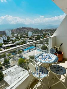 a balcony with two tables and chairs and a view of a city at Nuevo, amoblado y las mejores vistas de amaneceres in Santa Marta