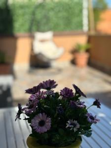 a bouquet of purple flowers in a vase on a table at Zefiro Ostia in Lido di Ostia