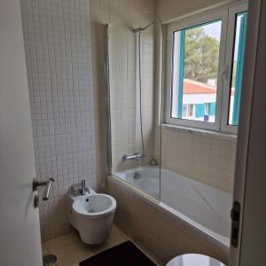 een badkamer met een bad, een wastafel en een toilet bij ALVOR VILLAGE BY THE SEA in Alvor