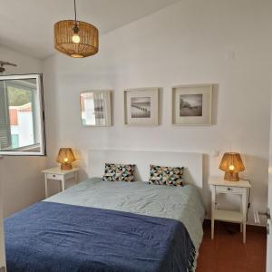 a bedroom with a bed with two tables and two lamps at ALVOR VILLAGE BY THE SEA in Alvor