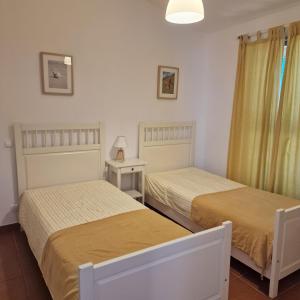 a bedroom with two beds and a table with a lamp at ALVOR VILLAGE BY THE SEA in Alvor