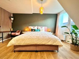 a bedroom with a large bed and a large window at Queen Loui: Comfy Apartment mit Tiefgarage in Dresden