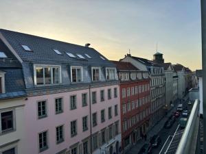 a group of buildings on a city street with cars at Queen Loui: Comfy Apartment mit Tiefgarage in Dresden