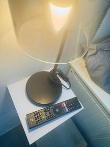 eine Lampe und eine Fernbedienung auf einem Tisch in der Unterkunft Studio meublé in Marseille