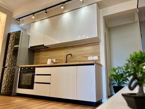 a kitchen with white cabinets and a sink at City Center Cozy Apartment in Tirana