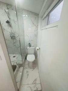 ein weißes Bad mit einer Dusche und einem WC in der Unterkunft Studio meublé in Marseille