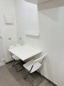 einen weißen Tisch und zwei Stühle in einem Zimmer in der Unterkunft Studio meublé in Marseille
