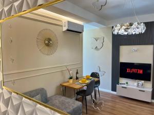 a dining room with a table and chairs and a mirror at City Center Cozy Apartment in Tirana +13 photos