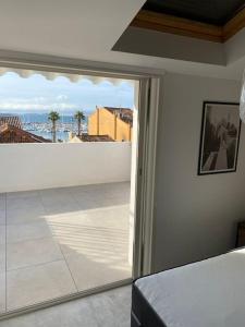a bedroom with a sliding glass door to a balcony at « L’Observatoire » 6 personnes in Bandol