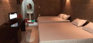 2 łóżka w pokoju z telewizorem i łazienką w obiekcie Djs Family Rest w mieście Kataragama