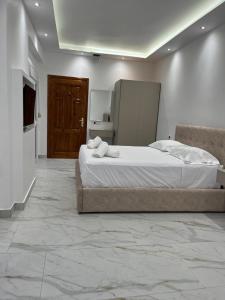 a bedroom with a large bed and a refrigerator at Harmony Apartments in Dhërmi