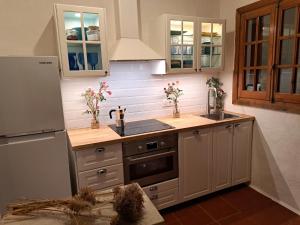 a kitchen with a sink and a refrigerator at Casa con jardin ,vistas al mar y atardecer en Playas de Fornells in Es Mercadal