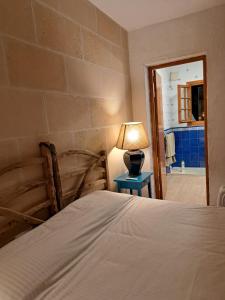 a bedroom with a bed and a lamp on a table at Casa con jardin ,vistas al mar y atardecer en Playas de Fornells in Es Mercadal