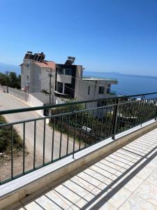 a metal railing in front of a building next to the ocean at Harmony Apartments in Dhërmi