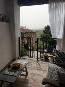 a room with a balcony with a bowl of fruit on a table at Casa Carrie in Válor