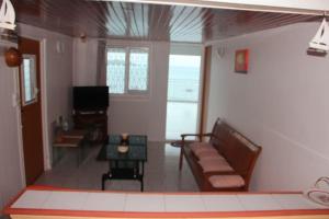 een woonkamer met een bank en een tafel bij Le carambolier maison avec vue imprenable in La Trinité