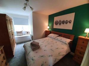 een slaapkamer met een groot bed met een groene muur bij Loch Awe Cabin, Portsonachan, near Dalmally in Portsonachan
