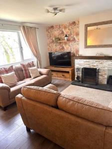 a living room with a couch and a fireplace at Loch Awe Cabin, Portsonachan, near Dalmally in Portsonachan