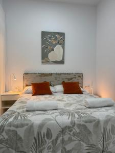 a bedroom with a large bed with orange pillows at Orange Suite by Alhaurín Loft City Center in Alhaurín de la Torre
