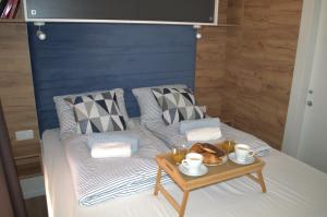 a bed with a table with a tray of food on it at Mobile home - EXCLUSIVE in Biograd na Moru
