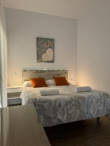 a white bedroom with a bed with two orange pillows at Orange Suite by Alhaurín Loft City Center in Alhaurín de la Torre