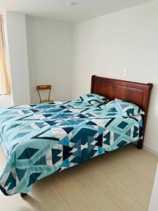 1 cama con edredón azul en un dormitorio en Amazing Studio-Centro Tunja, en Tunja