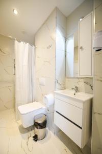 Hotel Blini في شكودر: حمام أبيض مع حوض ومرحاض