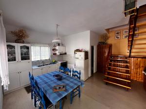 a kitchen with a table and blue chairs in it at Anna's House in Kokkino Nero
