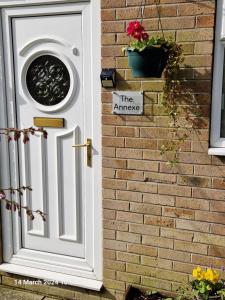 a white door on a brick wall with a sign on it at The Annexe in Bridlington