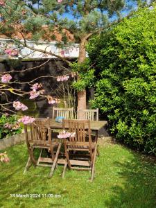 a wooden table and two chairs sitting next to a tree at The Annexe in Bridlington