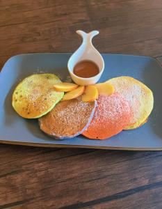 due pancake su un piatto con una tazza di sciroppo di The Enchanted Forest a Antigua Guatemala