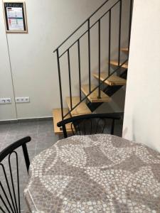 uma mesa com cadeiras e uma escada num quarto em Covo Residence - Casa Santiago em Vila Nova de Paiva